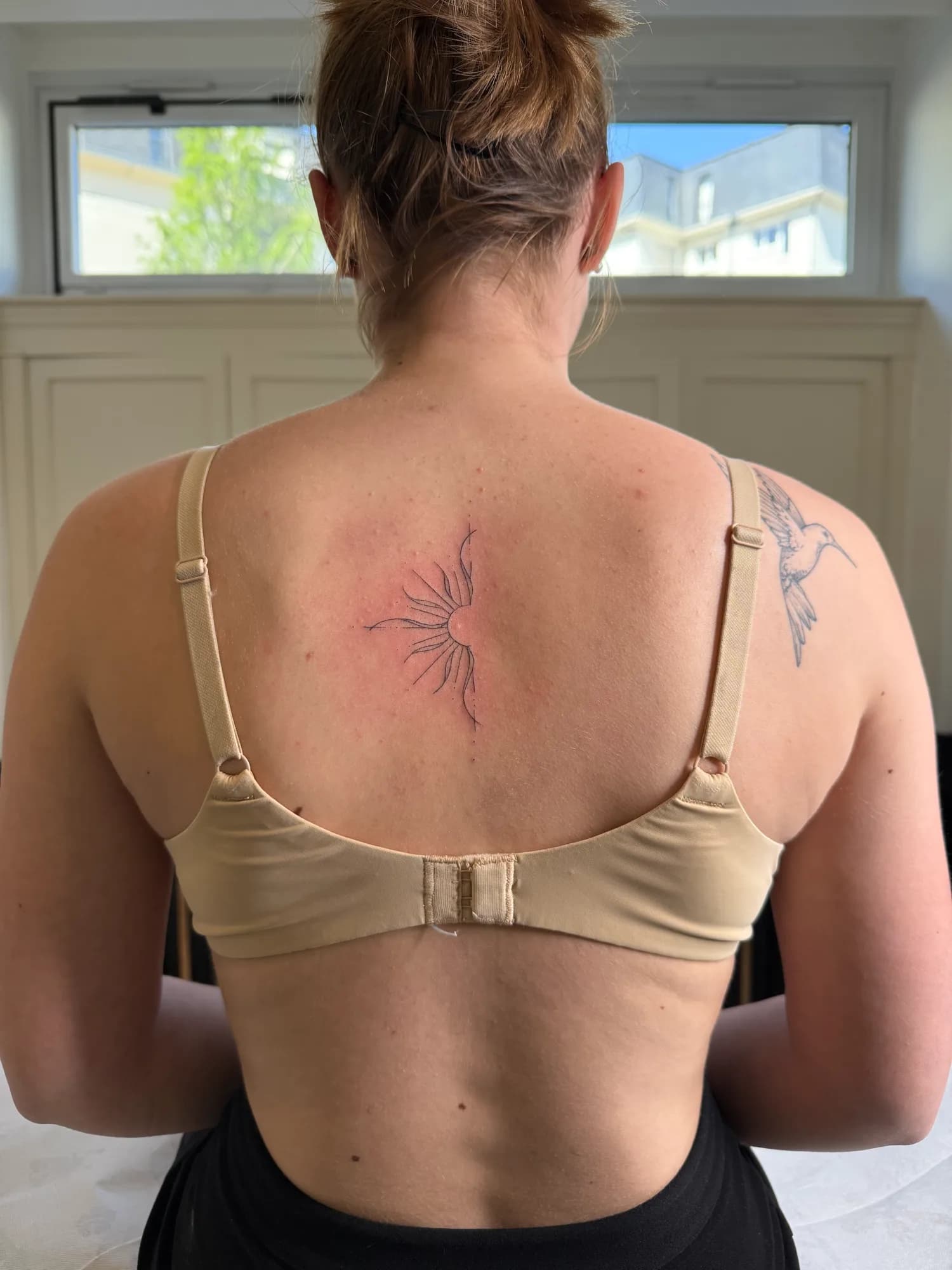 Tatouage ornemental rayonnant dans le dos, trait fin