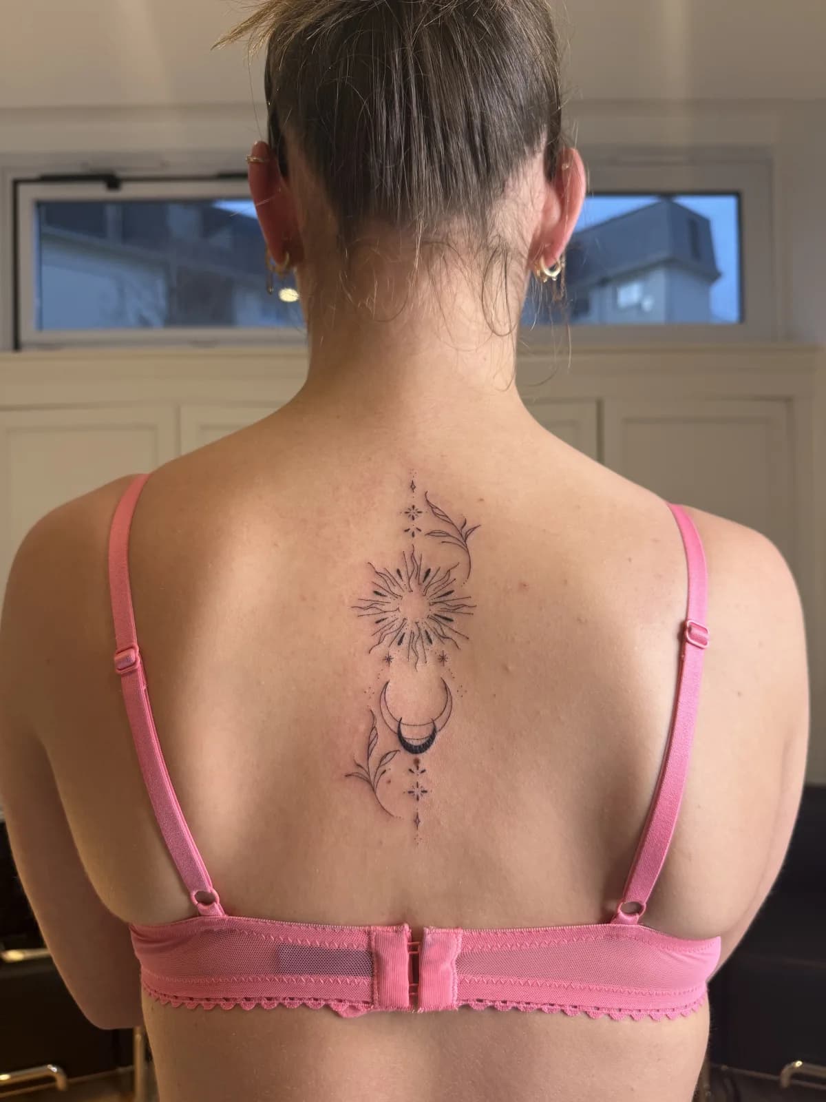 Tatouage ornemental soleil et lune le long de la colonne, trait fin