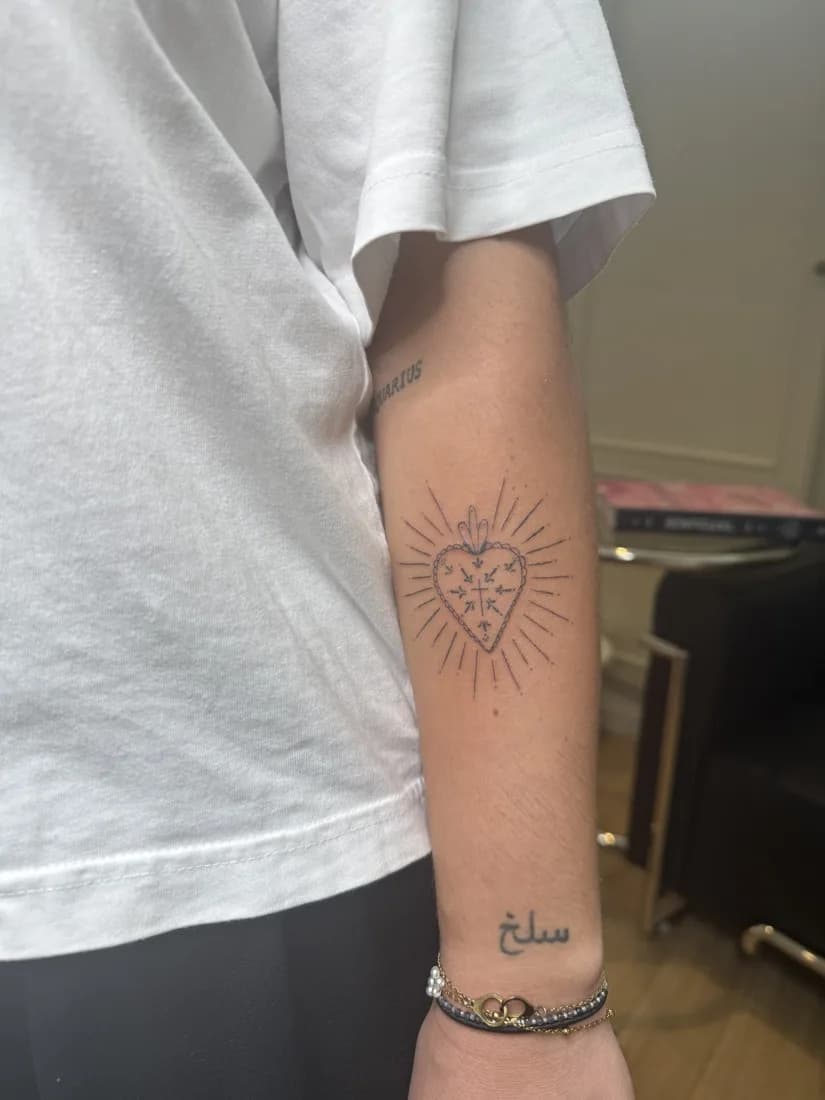Tatouage ornemental fin sur le bras, motif rayonnant