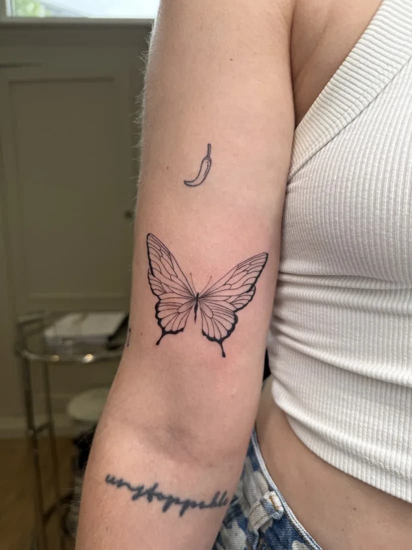 Papillon en trait fin sur l’avant-bras
